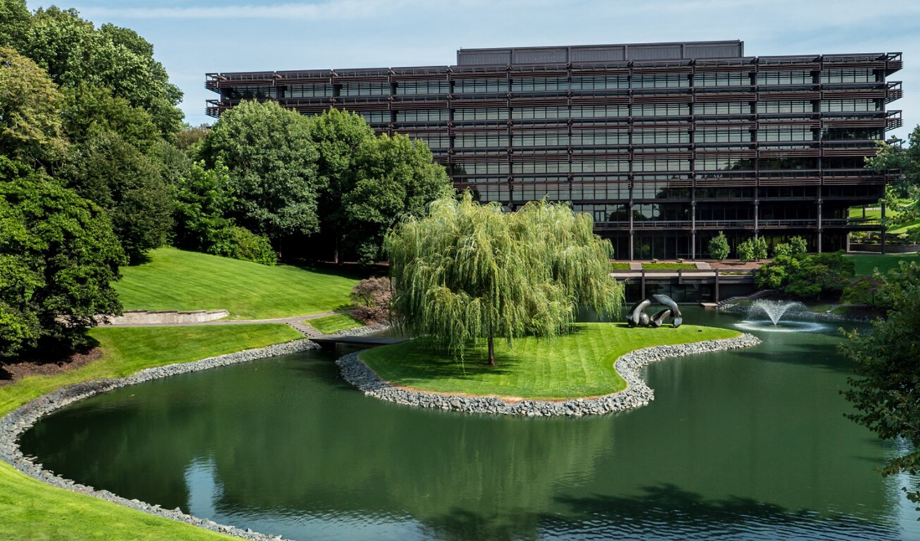 Вигляд головного офісу компанії John Deere із повітря на фоні ставка та дерев.